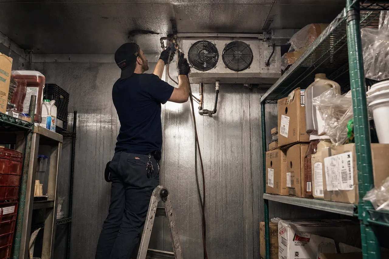 Technician servicing a walk-in cooler